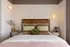 Inviting bedroom featuring a cozy bed with stylish pillows, ambient lighting, and chic decor elements.