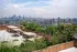 Chic rooftop patio with lush greenery, stylish seating, and stunning city skyline views.