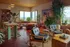 Chic open-plan living room featuring vibrant interiors with cozy seating, lush indoor plants, and panoramic city views through large windows.
