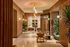 Luxurious apartment lobby with elegant wood paneling, stylish seating, and lush greenery, creating a welcoming atmosphere.