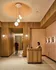 Elegant apartment lobby featuring warm wood paneling, stylish pendant lighting, and a welcoming reception desk.