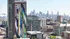 Dynamic cityscape view featuring a vibrant mural on a modern high-rise, with a stunning skyline in the background.