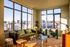 Bright, modern living room with large windows, stylish furniture, and a cozy ambiance, offering stunning urban views.