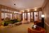 Chic lounge area with plush green and orange velvet seating, sleek wooden accents, and ambient lighting.
