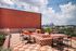 Chic rooftop terrace with stylish red and white checkered tiles, cozy seating, and stunning city skyline views, perfect for relaxation and entertainment.