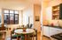 Bright and modern apartment featuring an open-concept living and dining area, with floor-to-ceiling windows, contemporary kitchen, and stylish decor.
