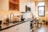 Modern kitchen with sleek cabinets, stainless steel appliances, and warm natural lighting, perfect for culinary creativity.