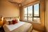 Cozy bedroom with chic lighting, contemporary decor, and a large window flooding the room with natural light.