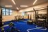 State-of-the-art fitness center with modern workout equipment and vibrant blue flooring, perfect for an invigorating exercise session.