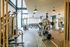 Bright and spacious gym with modern fitness equipment, large windows, and stylish lighting fixtures.