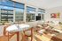 Bright and inviting living space with large windows, chic modern furniture, and vibrant artwork, creating a cozy yet stylish atmosphere.