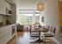 Bright open-concept apartment with a stylish kitchen, modern dining area, and cozy living space bathed in natural light.