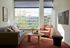 Bright and modern living room with stylish furniture, large windows offering a scenic view, and cozy decor accents.