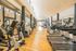 Modern gym featuring a variety of cardio equipment with large windows and a bright, spacious design.
