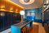 Modern parcel locker room featuring elegant lighting, a sleek central table with stools, and stylish wall lockers.