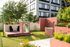 Inviting urban courtyard with lush greenery, playful seating, and modern architectural elements for relaxing outdoor enjoyment.