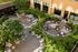 Charming outdoor courtyard featuring elegant seating, lush greenery, and intimate table settings for a serene retreat.