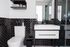 Sleek modern bathroom with black subway tiles, elegant vanity, and glass shower enclosure.