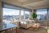 Chic city apartment with panoramic windows offering stunning urban views, featuring a cozy open-plan living area with modern decor.