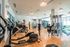 Modern fitness center with state-of-the-art gym equipment, sleek wood flooring, and bright lighting offering an energetic workout environment.