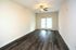 Bright and inviting living room with sleek hardwood floors, ceiling fan, and double glass doors leading to ample natural light.