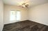 Bright and airy room with elegant wood flooring, ceiling fan, and double glass doors leading to a serene view.