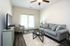 Inviting living room with plush gray sofa, elegant coffee table, and stylish armchair, enhanced by natural light from double doors.