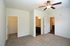 Bright and spacious bedroom with plush carpeting, walk-in closet, and modern ceiling fan, complemented by en-suite bathrooms for ultimate comfort.
