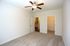 Bright and inviting bedroom with plush carpeting, ceiling fan, and walk-in closet, perfect for comfort and style.