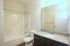 Elegant bathroom featuring a sleek granite countertop, polished fixtures, and a pristine bathtub for a luxurious apartment living experience.