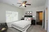 Inviting bedroom with elegant decor, featuring a cozy queen-sized bed, modern black nightstands with lamps, and stylish wall art, creating a relaxing ambiance.