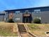 Charming two-story apartment building with modern brick exterior, large windows, and with lush green landscaping.