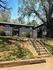Charming apartment building surrounded by mature trees and set against a clear blue sky, featuring well-maintained landscaping to welcome you home!