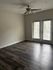 Bright, spacious room with elegant dark hardwood flooring and French doors leading to a serene balcony.