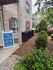 Inviting leasing office entrance adorned with lush greenery and charming brickwork at a modern apartment complex.