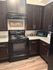 Cozy kitchen with rich dark wood cabinets, modern appliances, and granite countertops, perfect for culinary creativity.