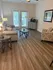 Inviting living room with modern furniture, elegant wood flooring, and natural light streaming through French doors.