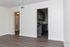 Inviting living space with elegant wood flooring leading to a modern kitchen featuring sleek cabinetry and stainless steel appliances.