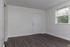 Bright and spacious room with modern wood flooring and large window offering nature views.