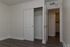 Bright, modern room with sleek wood flooring and a spacious walk-in closet, perfect for comfortable living.
