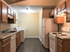 Modern kitchen with sleek wooden cabinets, complete with a stove, refrigerator, and in-unit laundry facilities.