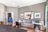Chic living room with modern decor, featuring stylish artwork, comfy striped sofa, and elegant side table in a brightly lit space.