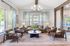 Chic living room with modern decor, featuring plush seating, a stylish chandelier, and large windows offering natural light.