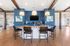 Elegant community lounge featuring a marble countertop island, stylish pendant lighting, and comfortable seating against a modern blue accent wall.