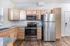 Modern kitchen with sleek stainless steel appliances, warm wooden cabinetry, and elegant granite countertops.