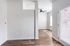 Bright open space with sleek wood flooring and abundant natural light, featuring a ceiling fan and modern design. Perfect for a stylish home or airy office setup.