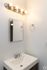 Bright and modern bathroom sink area featuring a sleek mirror, elegant faucet, and ambient lighting.
