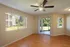 Agora at Port Richey, living room, large window with vertical blinds, sliding glass door to large patio, simulated hard wood floors, ceiling fan with light