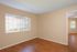 Agora at Port Richey, bedroom, large window with vertical blinds, door to living room, simulated hard wood floors