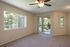 Agora at Port Richey, living room, large window with vertical blinds, sliding glass door to large patio, carpet, ceiling fan with light